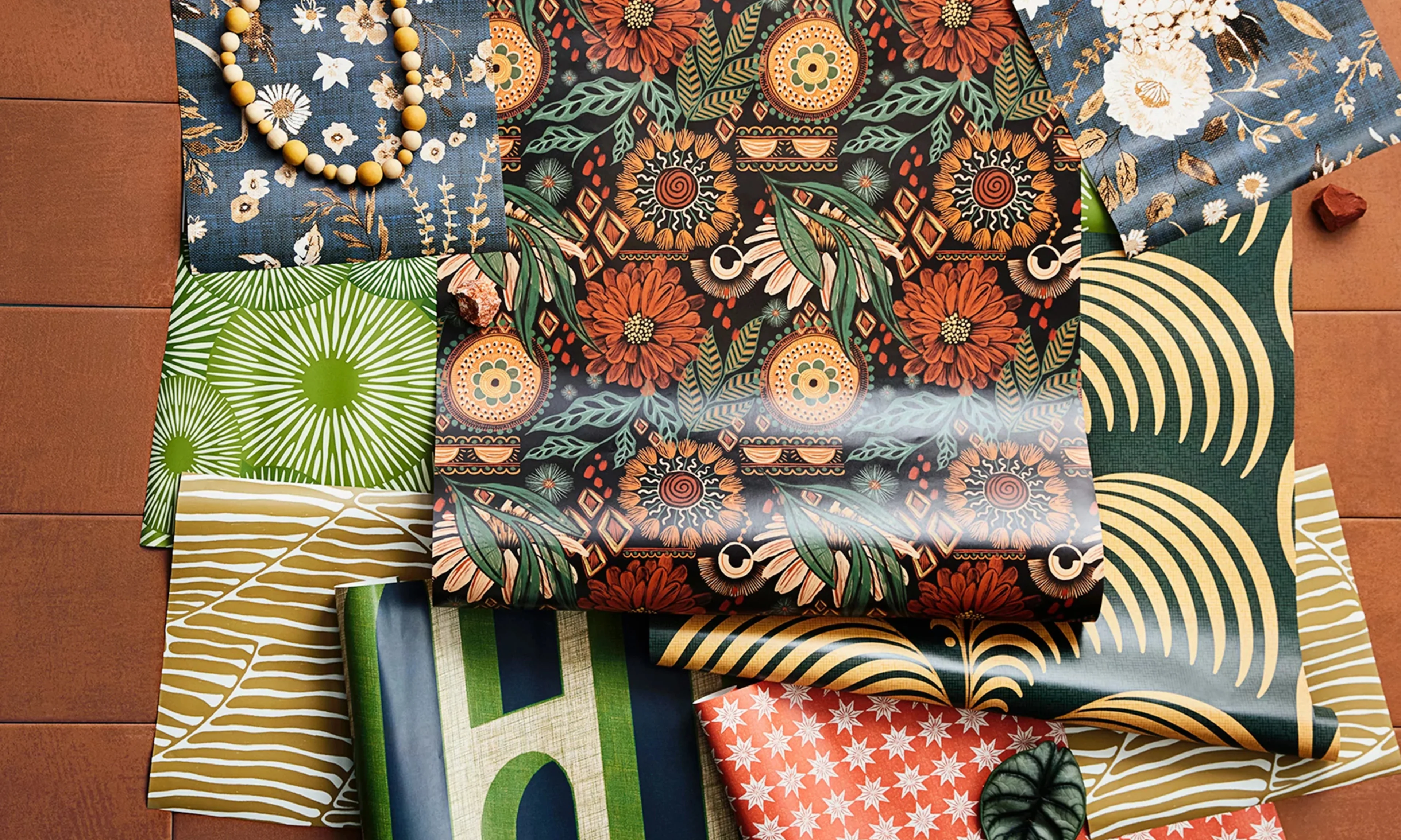 Boho peel and stick wallpaper rolls and swatches styled together.