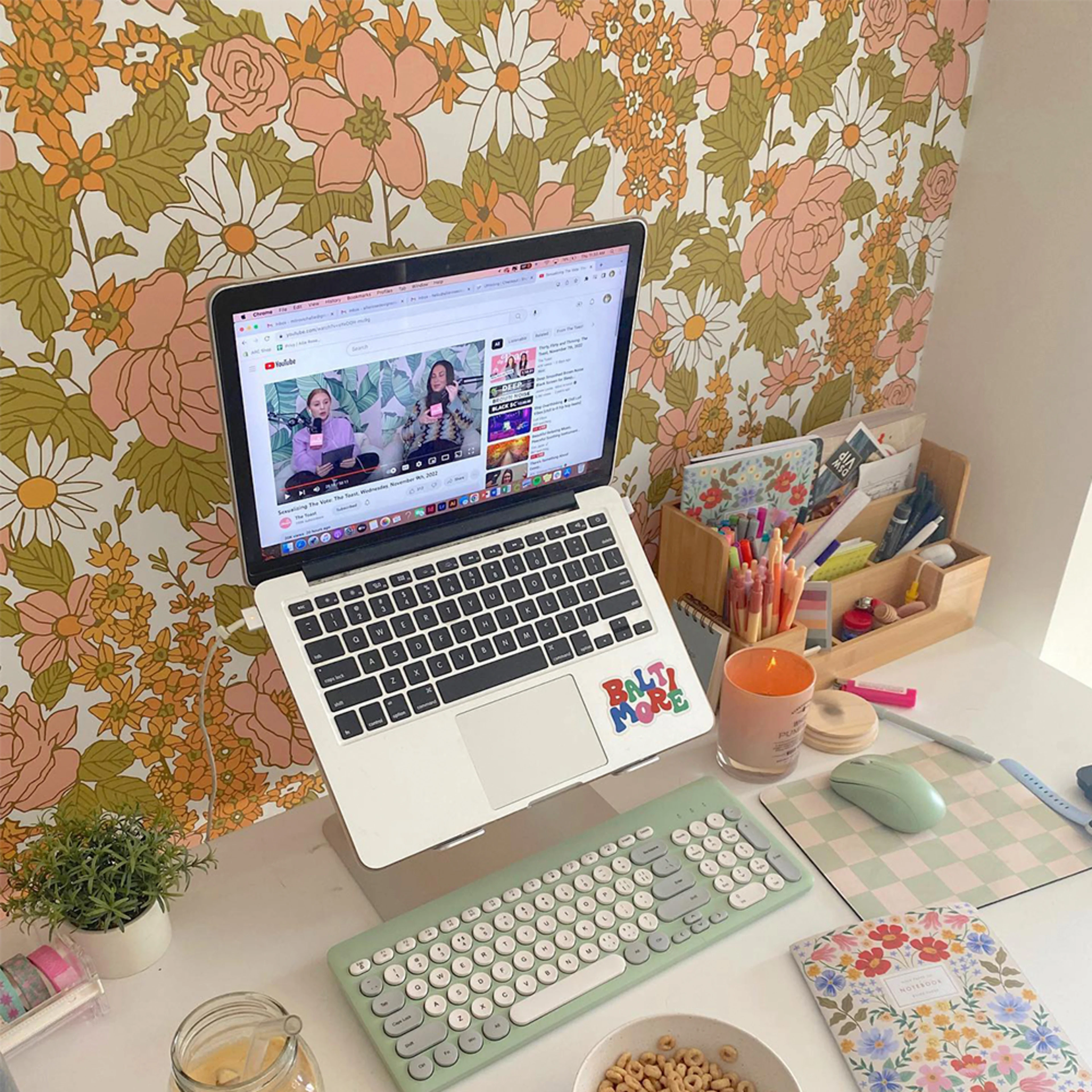 Vintage floral wallpaper behind a desk and laptop.
