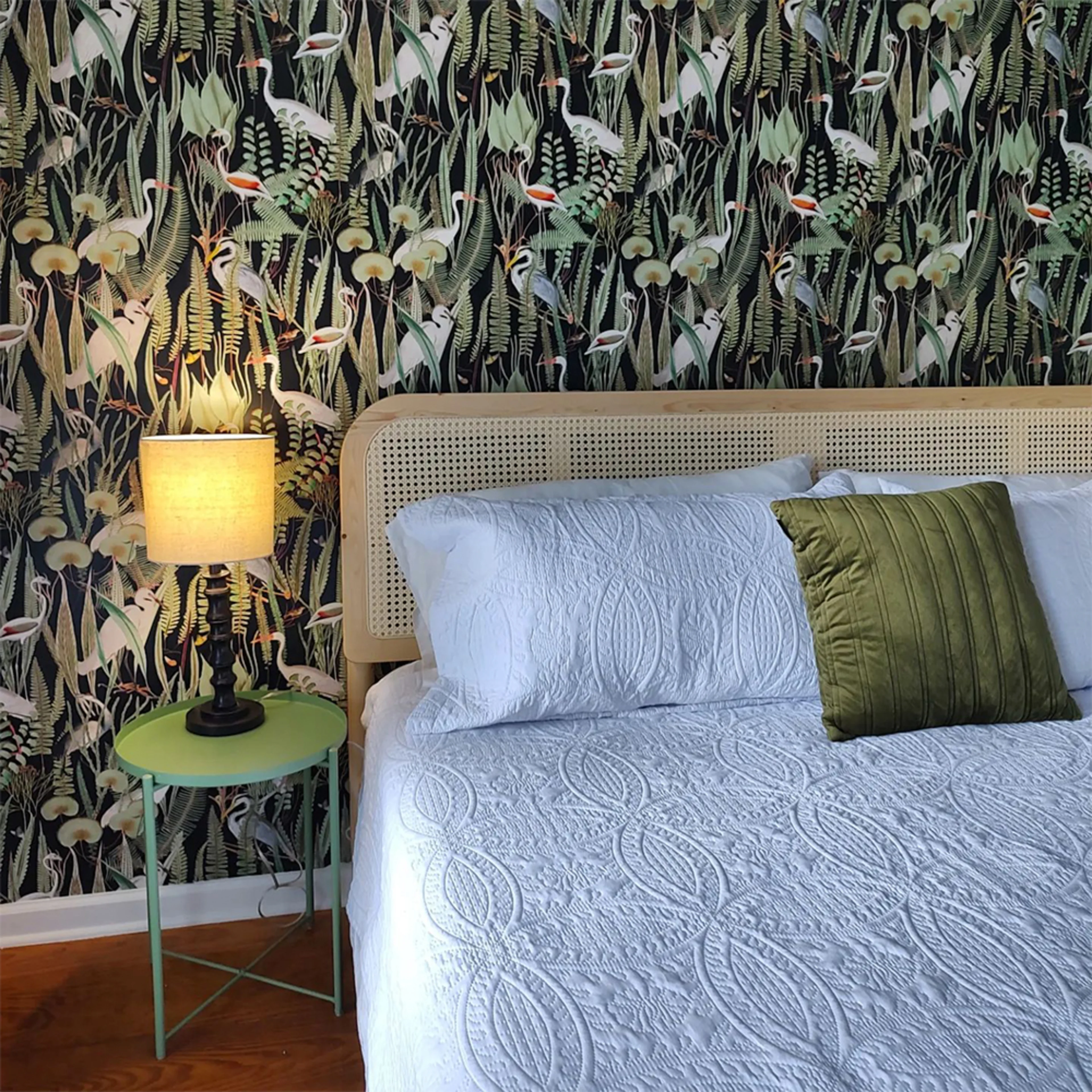 Heron wallpaper behind bed.