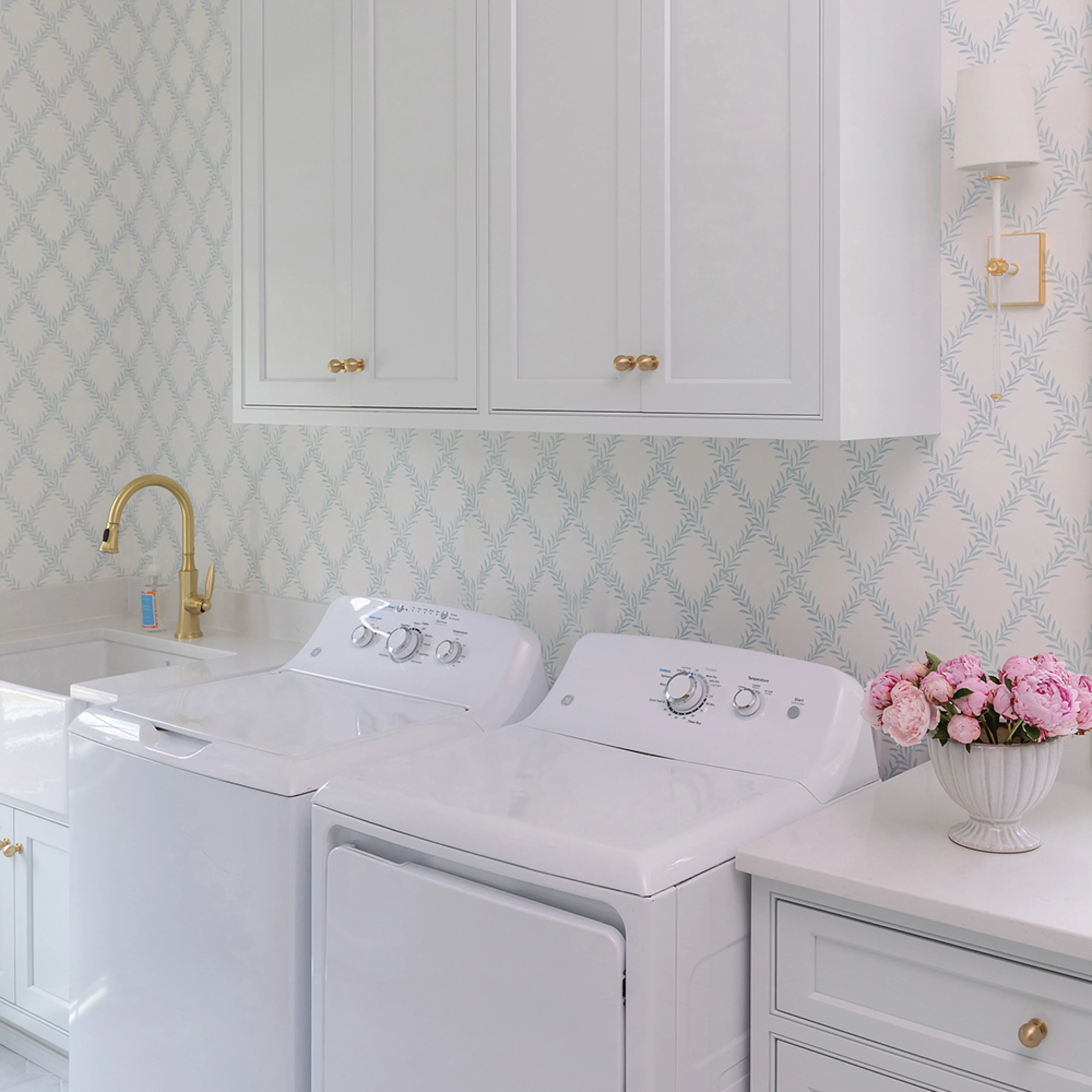 Laundry room with preppy trellis wallpaper.
