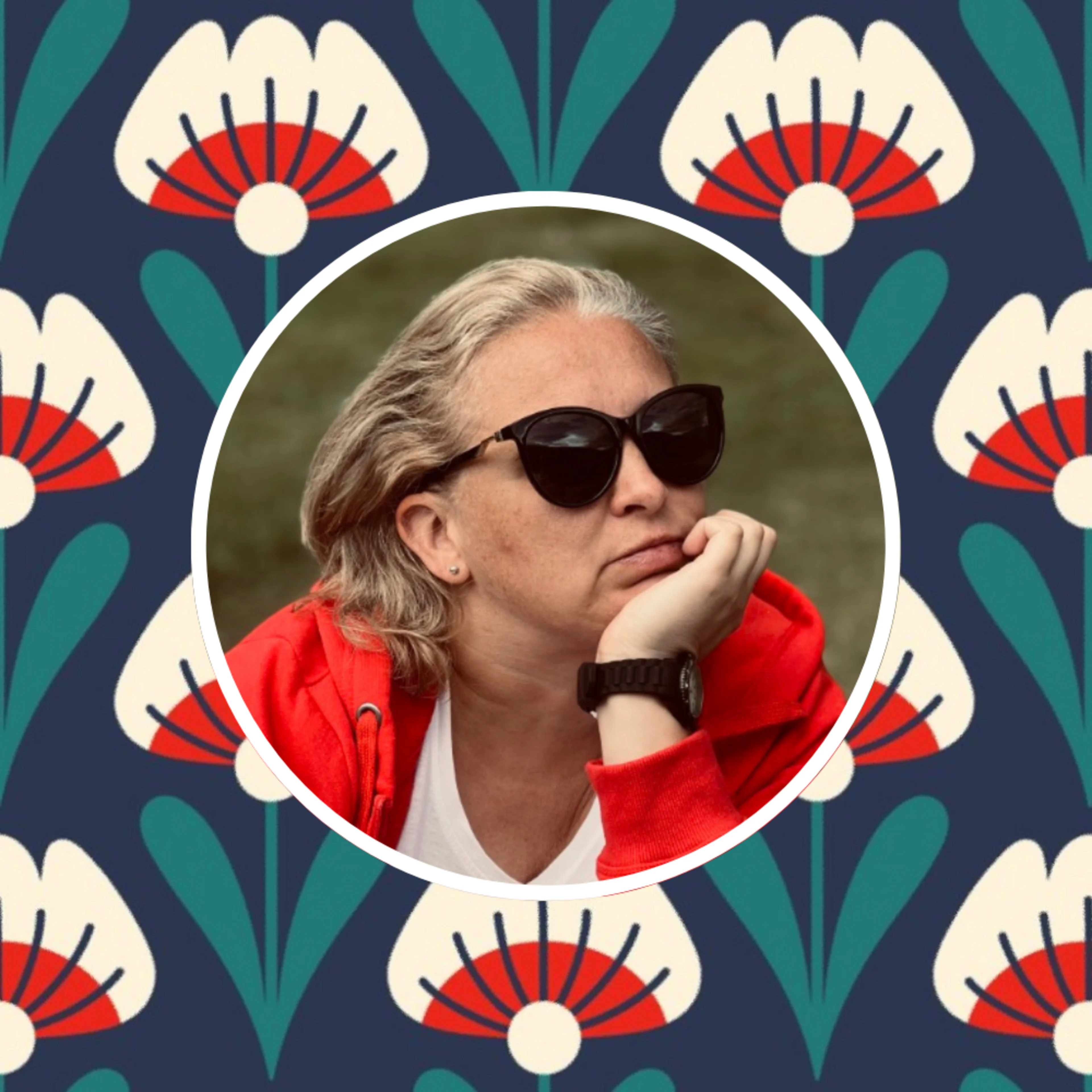 Headshot of Elvyra with one of her prints in the background.